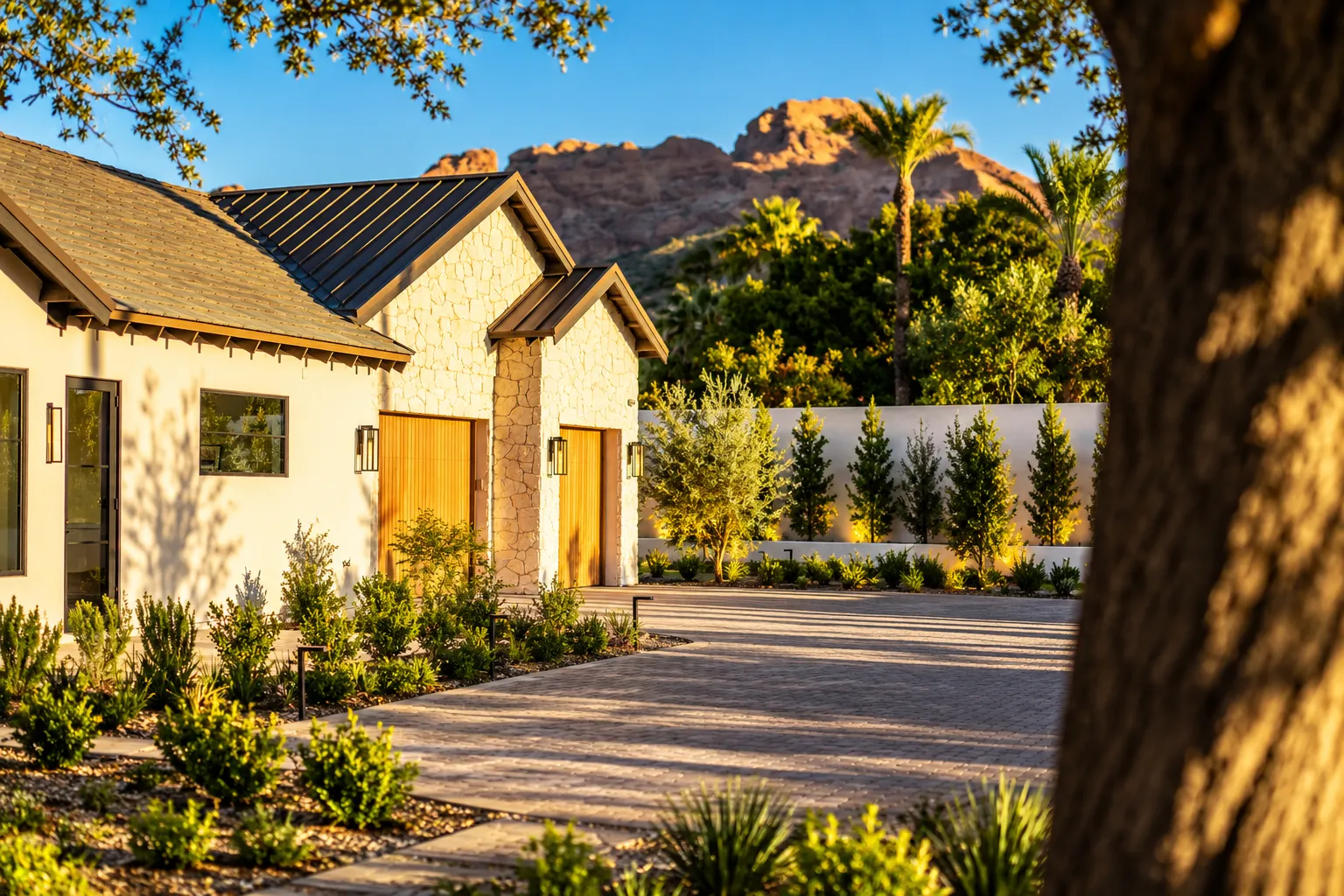 Stone garages and paver motor court at golden hour with Camelback Mountain beyond