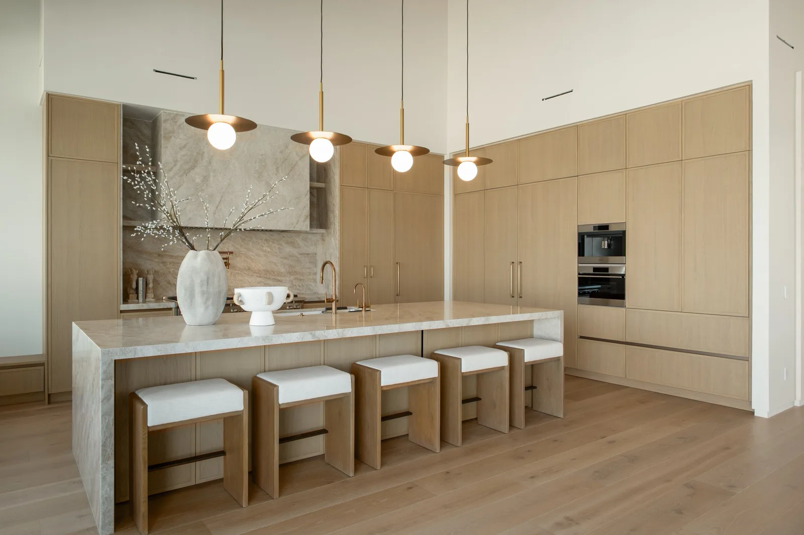 Kitchen with bookmatched stone, waterfall island seating and oak cabinetry